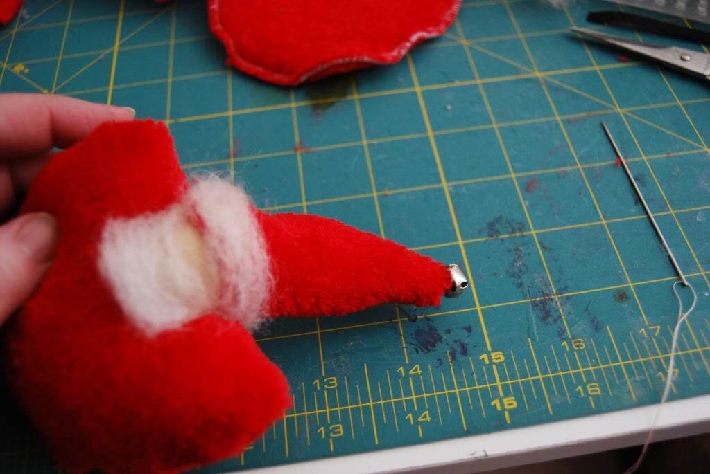 Sew a tiny jingle bell to the very tip of the hat. (or hot glue)