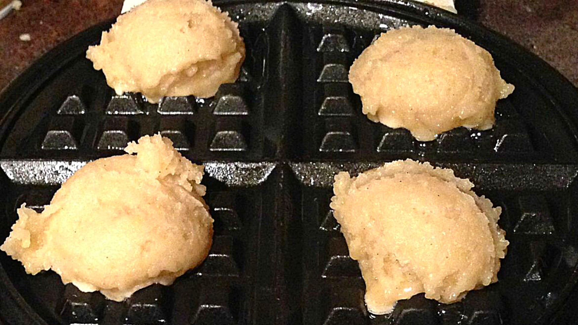 Belgian Waffle Cookie dough scoops  on a waffle iron. 