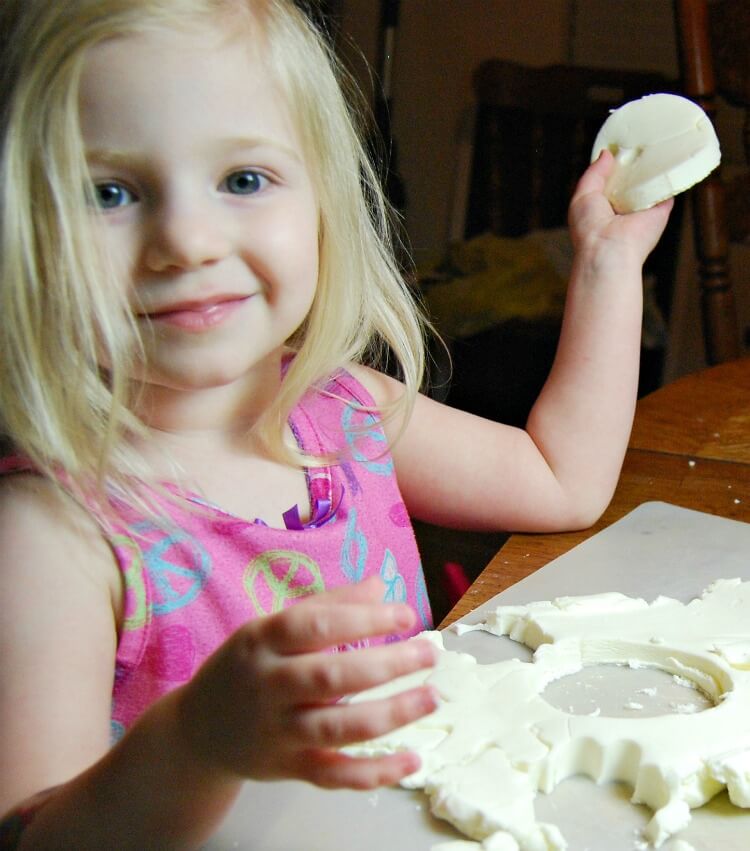 A little girl smiling and playing with Cool Whip Play Dough