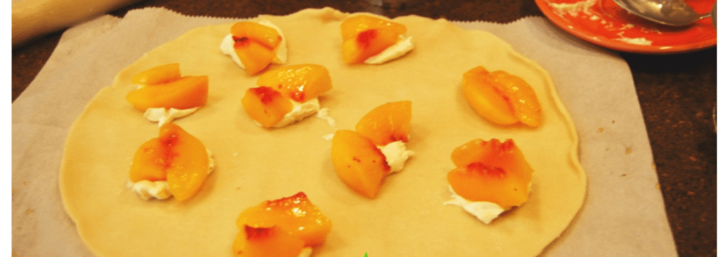 One pie crust with peaches and cream cheese on top of it