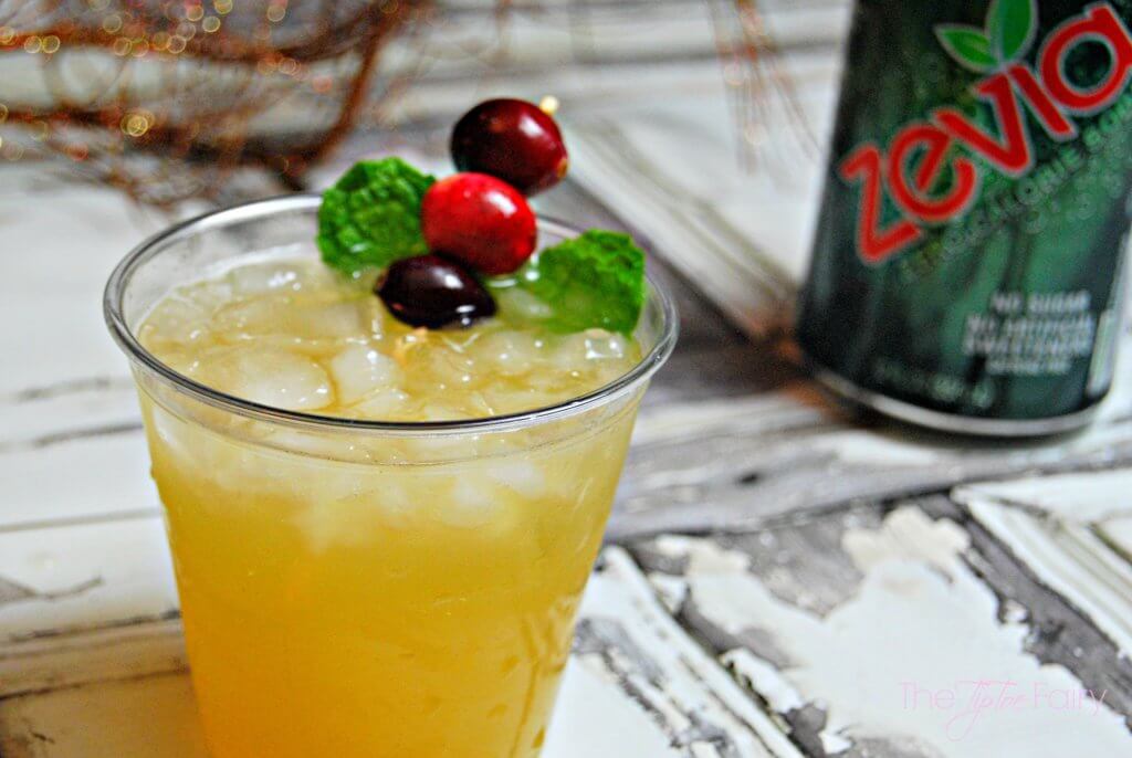 a close up of the tipsy reindeer drink with a green can of Zevia ginger ale with a sprig of gold in the background