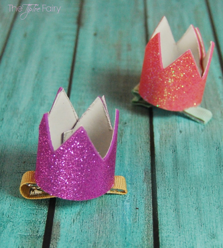 Two finished Mini Crown Hair Clips on a blue wooden background