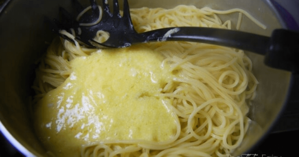 Mixing in eggs and parmesan to the spaghetti