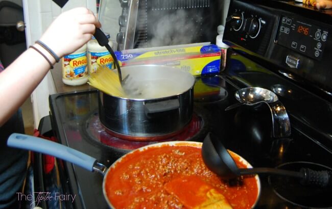 Cooking spaghetti and meat sauce on the stove for million dollar spaghetti casserole