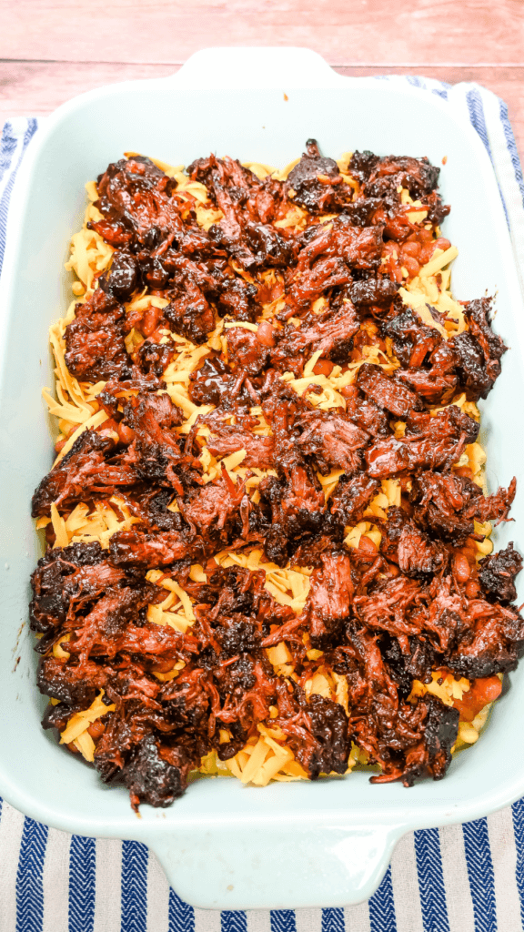 Fourth layer of Cowboy Brisket Casserole is brisket in a light blue casserole dish