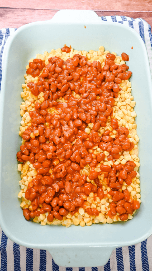 After baking, third layer of Cowboy Brisket Casserole is ranch style beans in a light blue casserole dish