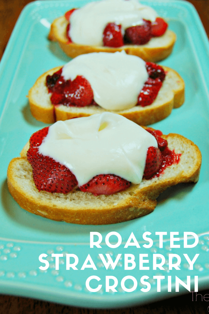 Three Slices of Roasted Strawberry Crostini topped with french cream on a blue platter