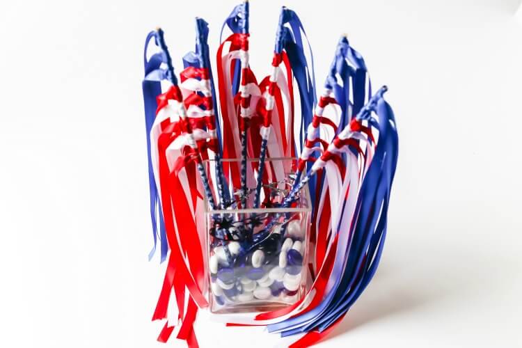 A vase full of DIY Patriotic Flag Waving Wands. 