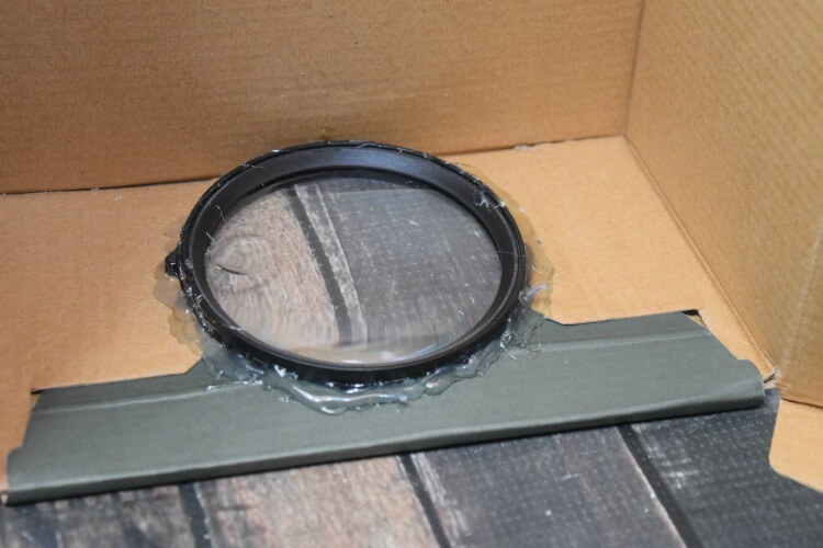 Hot glue the magnifying glass into the circle you cut out of the shoe box.