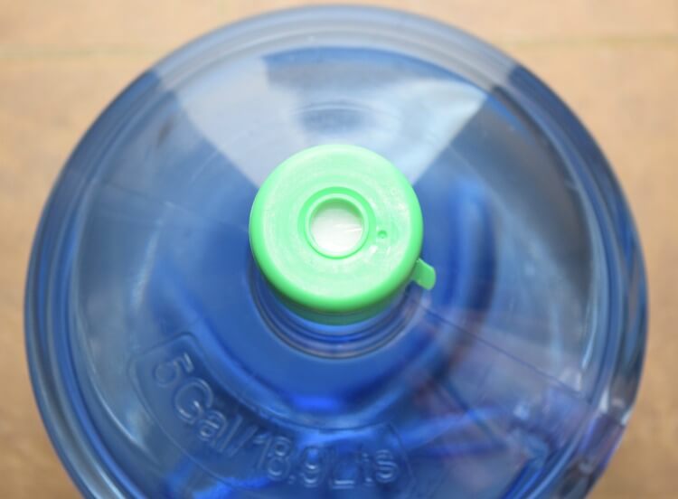 The top of the water bottle with the insert that prevents it from spilling out when loading.