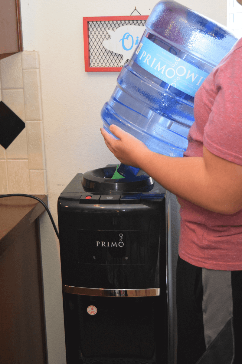 Loading the water bottle onto the Primo Water Dispenser