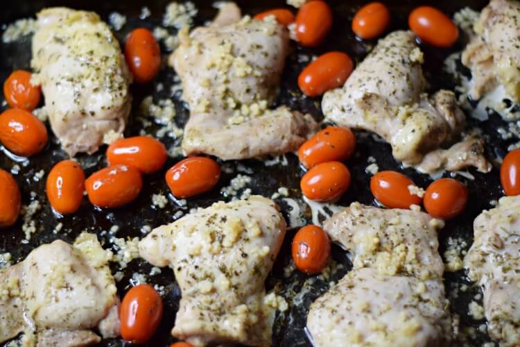 adding garlic to Chicken Thighs and grape tomatoes