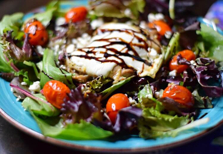 Low Carb Sheet Pan Caprese Chicken Thighs over salad close up