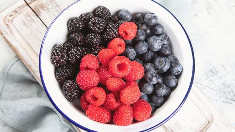 A bowl of raspberries, blueberries, and blackberries. 