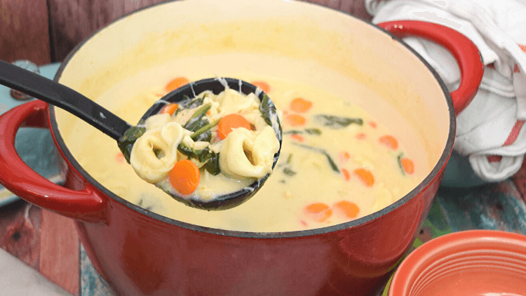 A red pot full of Creamy Chicken Alfredo Tortellini Soup