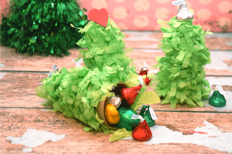 The mini christmas pinata opened on its side and spilling candy.