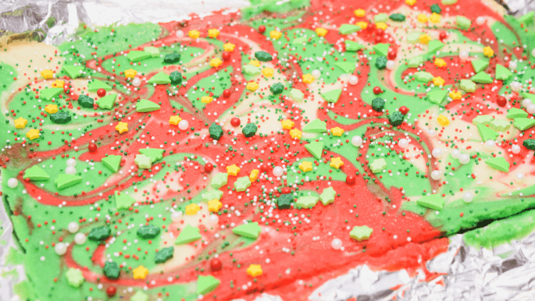 The Christmas Swirl Cheesecake Bars with added sprinkles and still in the pan. 
