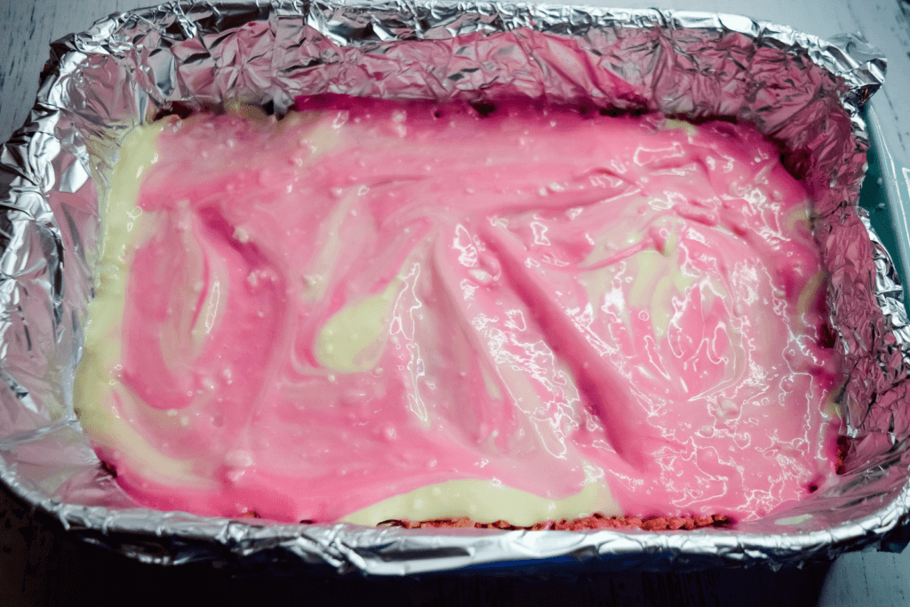 Foiled casserole dish with the pink and white batter. 