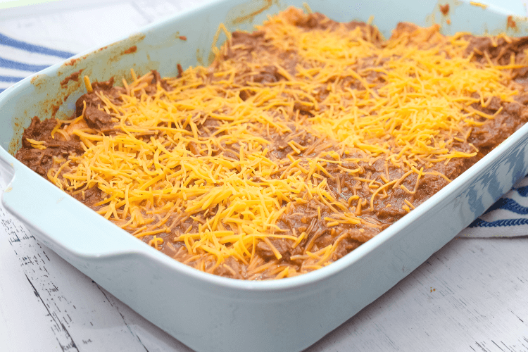 A pan of Tex Mex cheese enchiladas with enchilada chili gravy ready to go in the oven