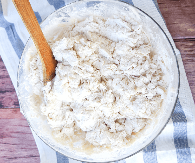 A bowl of crumbly pizza dough before the kneading process