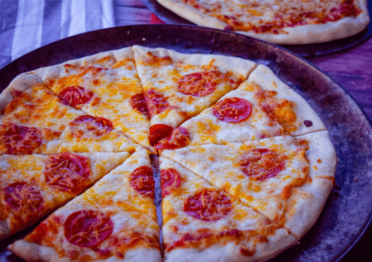 Pepperoni Pizza sliced up into 8 slices on a pan. 