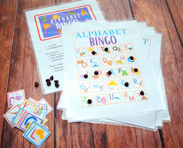 Alphabet Bingo with a pile of bingo cards and a pile of bingo chips with letters on them. 