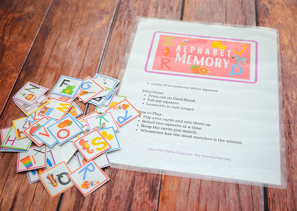 Alphabet Memory Game on a brown table with alphabet letter squares game pieces in a big pile. 