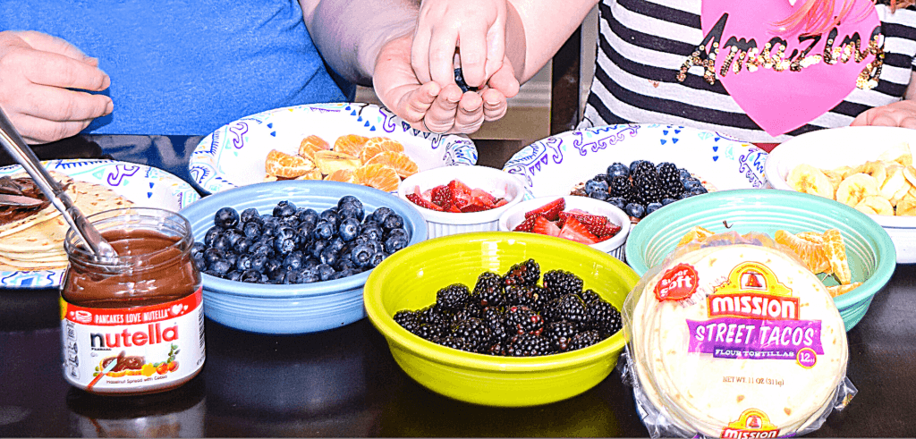 Bowls of berries and fruits with a jar of Nutella and Mission Street Tacos. 