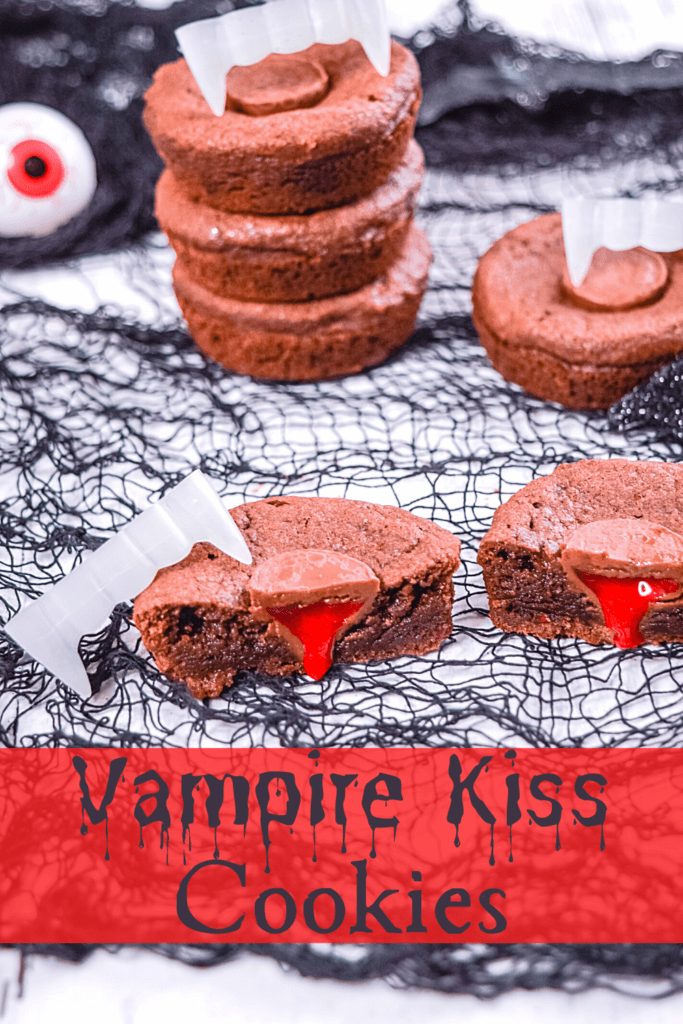Vampire Kiss Cookies in a stick with a a Vampire Kiss Cookie sliced in half with the strawberry filling dripping down like blood with a pair of vampire teeth on top of the cookie. 