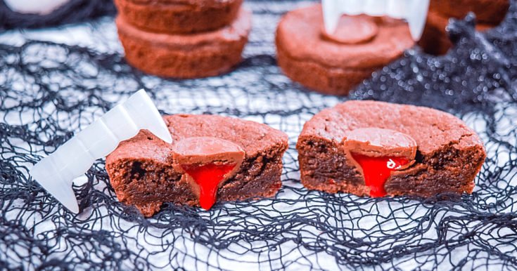 Close up view of the sliced in half Vampire Kiss Cookie showing the strawberry filling dripping down like blood.