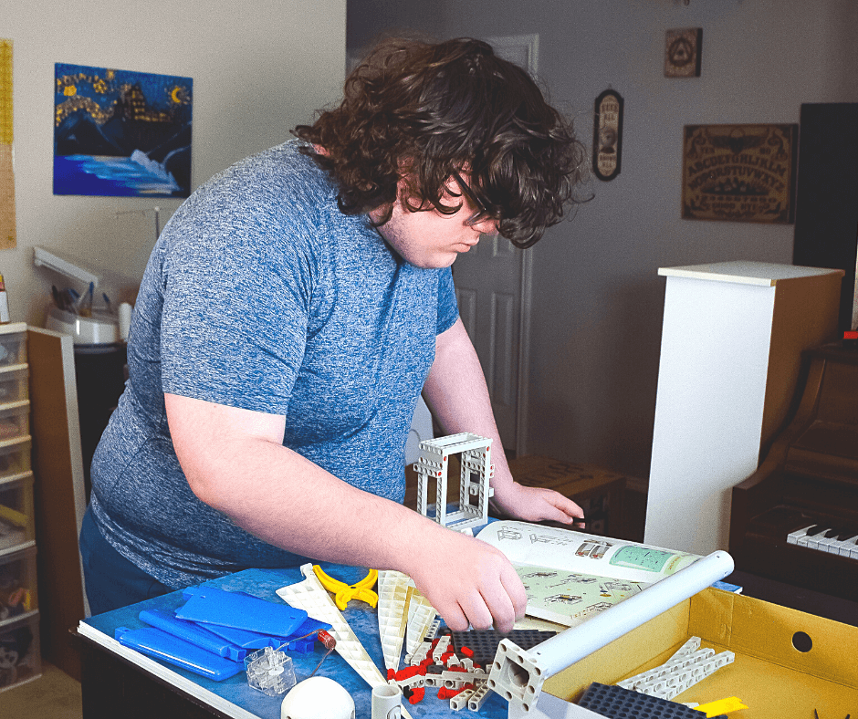 Teenage boy putting a wind turbine together. 