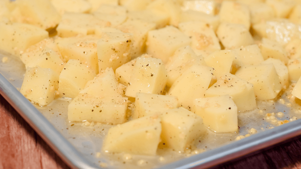 Raw potatoes cut into cubes with salt, pepper, olive oil, and garlic. 