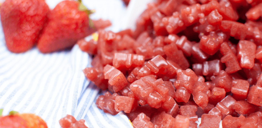 Close up image of a pile of strawberry puree gummy bears. 