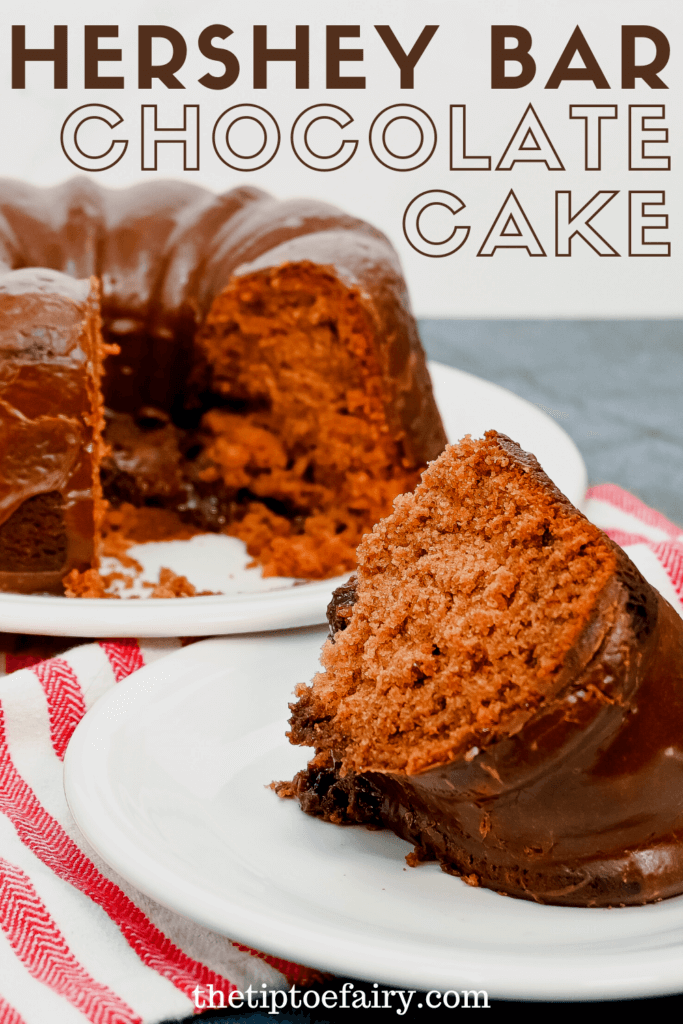 A close up slice of Hershey Bar Chocolate Cake on a white saucer with the cut cake behind it. 