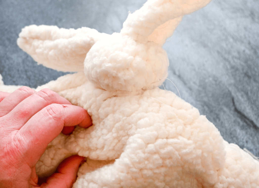 Whipstitching the neck to the body of the bunny doll. 