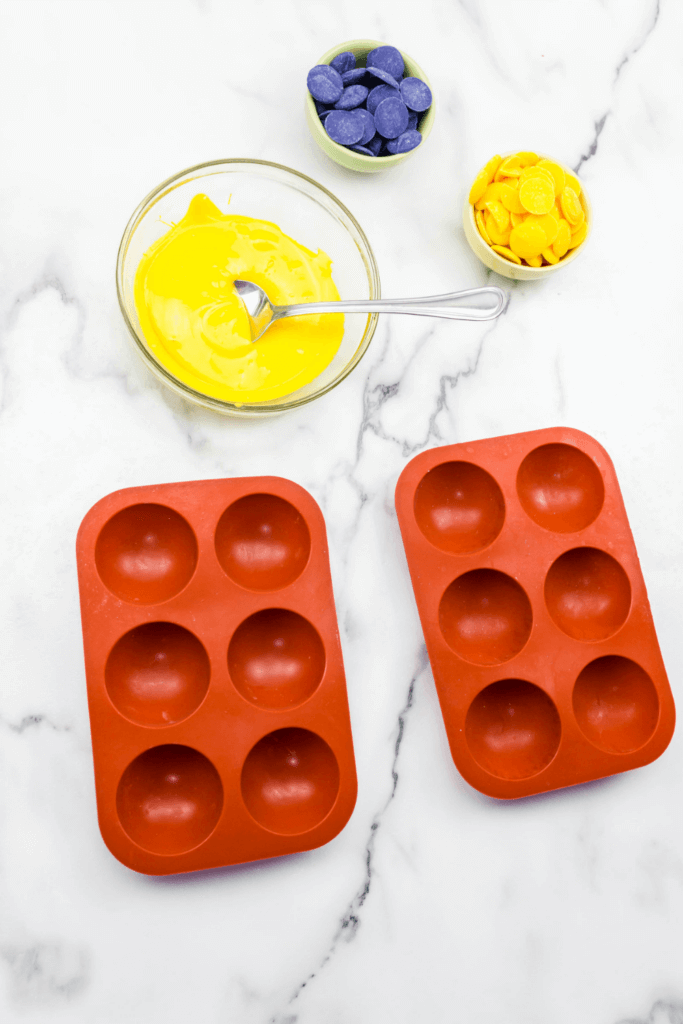 Melted yellow candy melts in a bowl and the molds ready to go. 