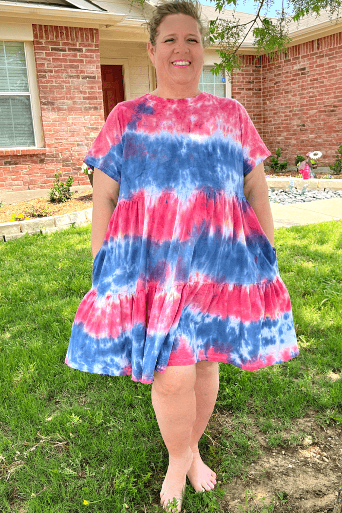 Me smiling with my hands in my pockets modeling my new red white and blue tie dye dress from Old Navy