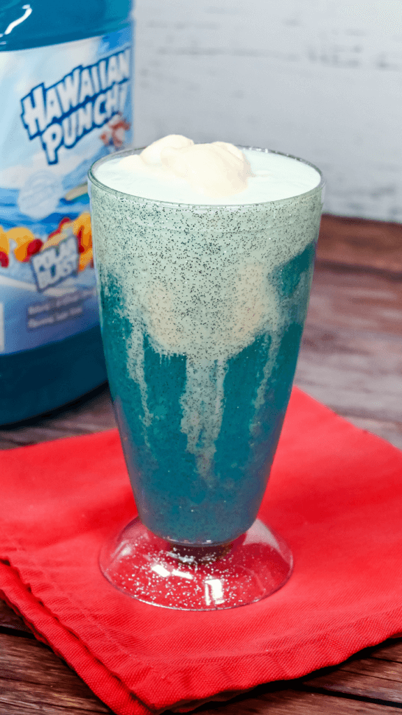 Vanilla Ice Cream in the top of the glitter glass of a Blue drink for the Shark Attack Ice Cream Float