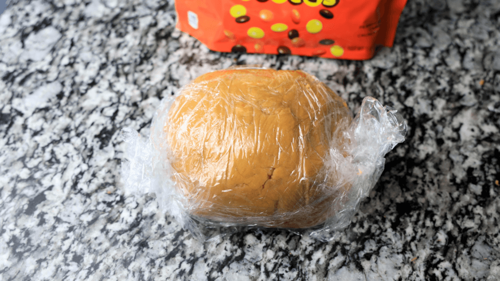 Wrapping the peanut butter dough in plastic wrap. 