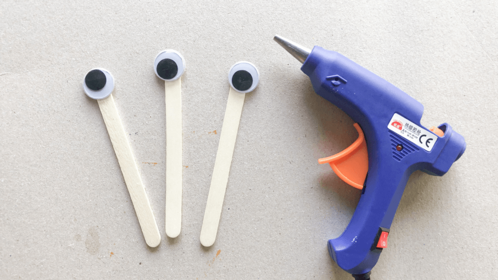 Making the popsicle sticks with googly eyes