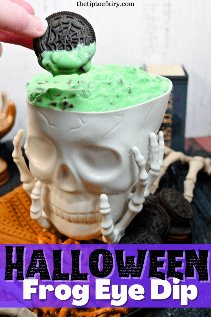 The title image with a close up view of the skull bowl full of the Halloween Frog Eye Dip with fingers holding a freshly dipped OREO cookie. 