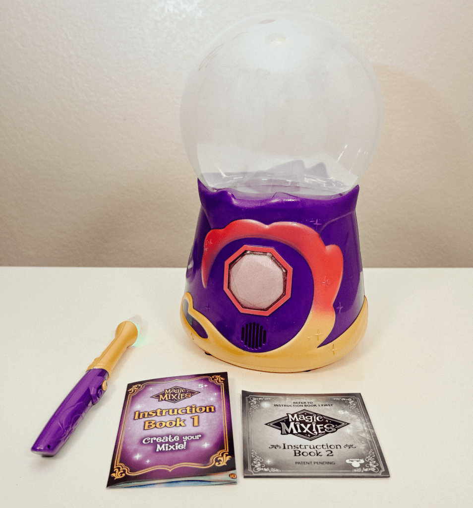 The Magic Mixies Magical Crystal Ball with the wand and both instruction books on a white table. 