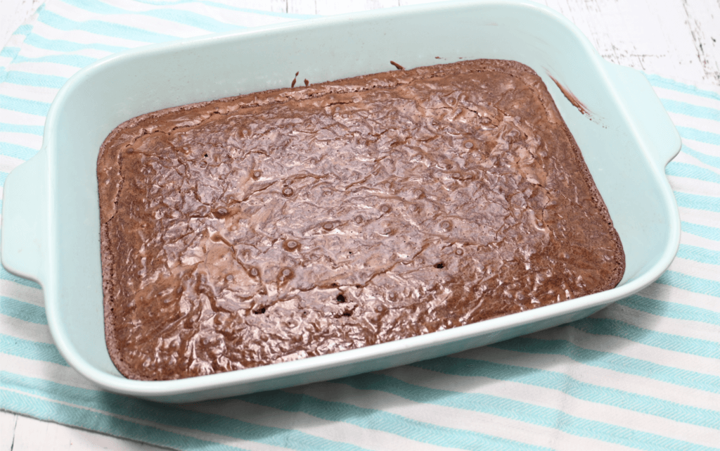 A light blue pan of brownies already baked. 