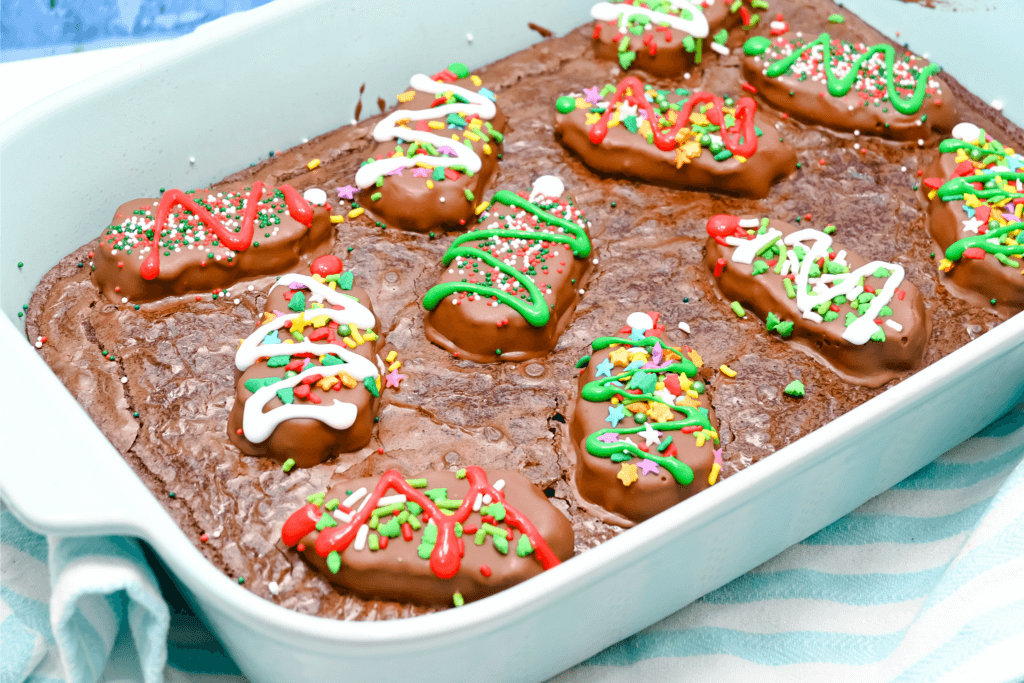 The Reese's Trees on top of the brownies decorated with cookie icing and sprinkles. 