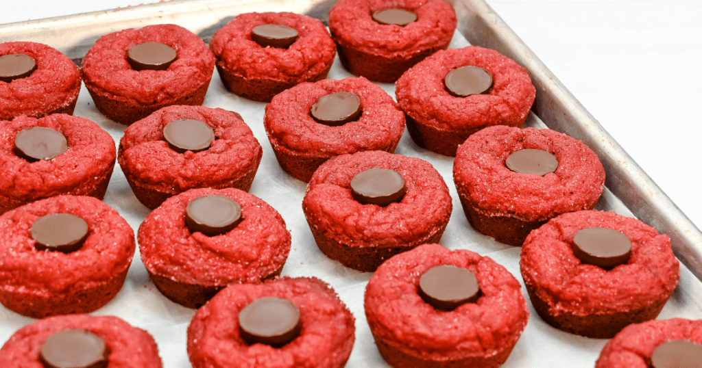 The Red Velvet Chocolate Lava Cake Cookies on a cookie sheet just after putting the Hershey's Kisses on them. 