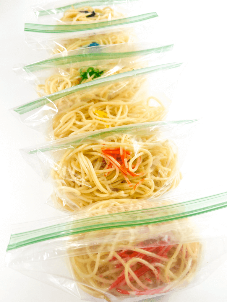 Adding the food dye to the ziplock bags of spaghetti