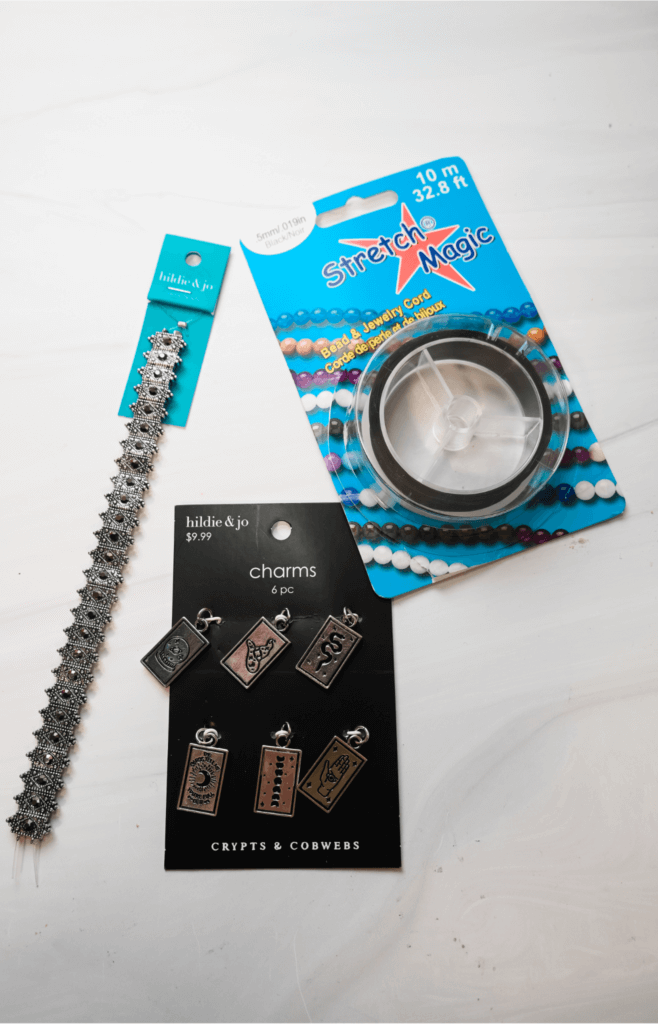 The supplies needed to make the tarot card charm stretch bracelet