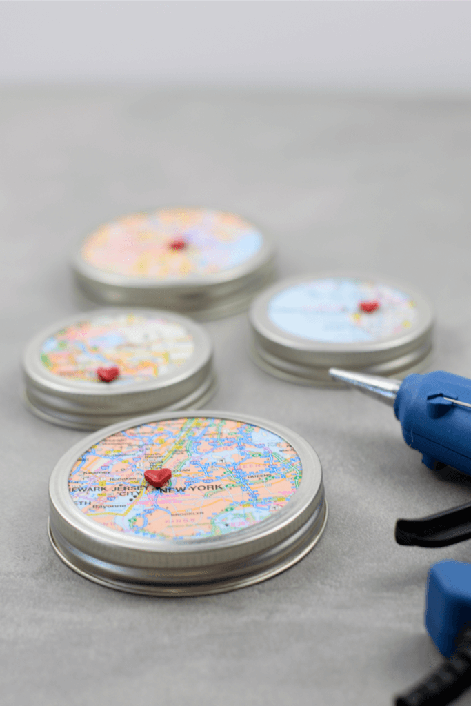 hot gluing the tiny heart buttons on the finished map ornament