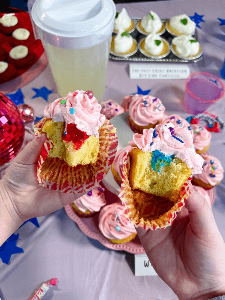 Two cupcakes that have been bitten in half to show the different colors for What's Your Era - one is Red and one is 1989