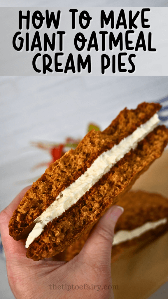 A hand holding half of an giant oatmeal cream pie